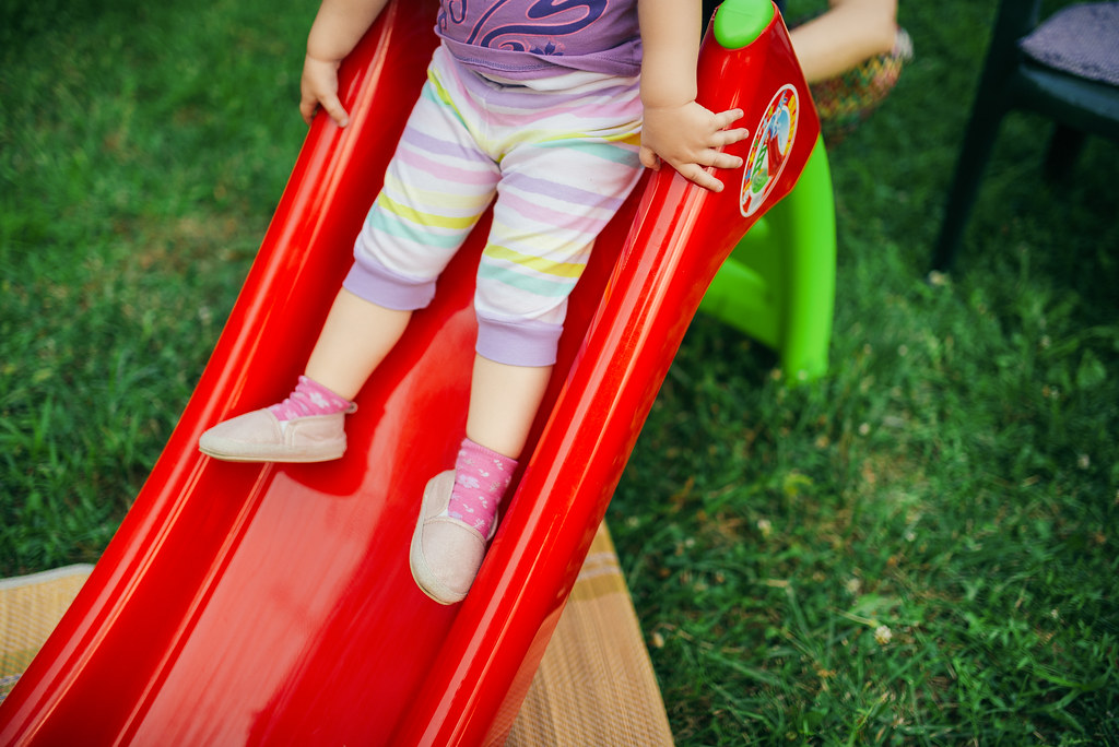 Kids Slide Safety Tips: 8 Rules for Safe Sliding at Home 2 Toddler sliding down a small kids slide feet-first at home
